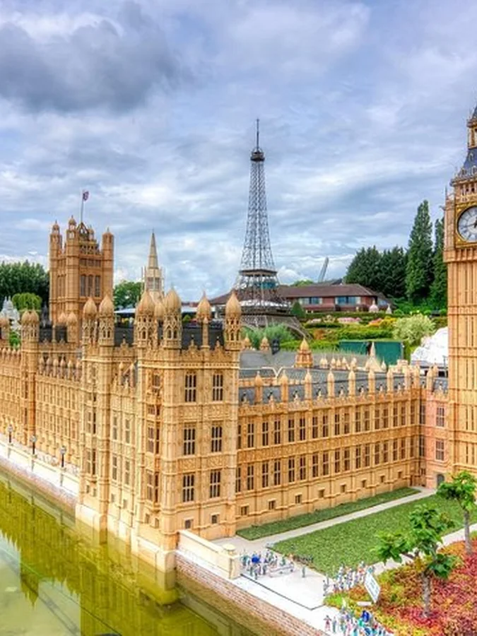 Miniatuurhuizen van het Parlement en Big Ben bij Mini-Europe, met de Eiffeltoren op de achtergrond